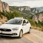 Élève conductrice au volant d'une voiture d'auto-école sur une route pittoresque de l'Ardèche