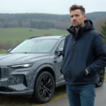 Homme en veste navy près d'un SUV prototype en campagne
