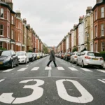 Rue urbaine britannique avec marquage au sol 30 mph à Londres, passage piéton et maisons victoriennes en briques rouges