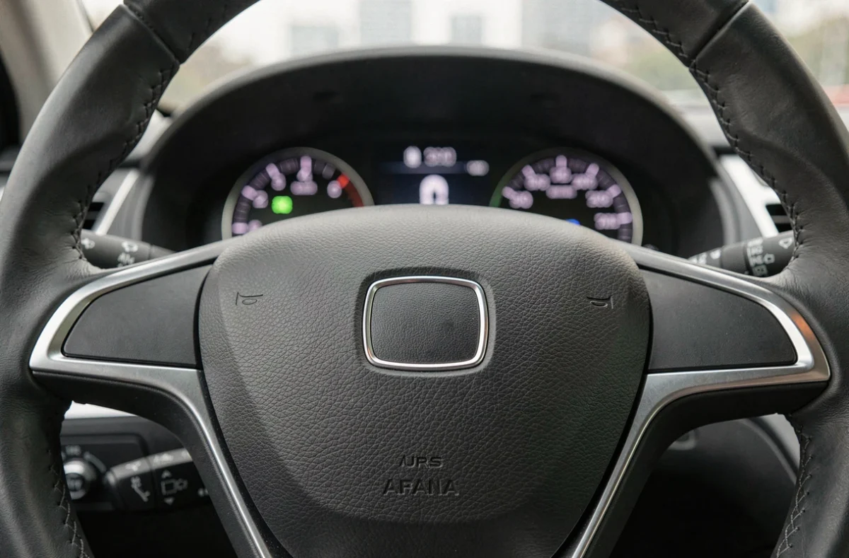 Volant de voiture avec logo de marque simplifié et plat au centre, vue intérieure d'un habitacle premium illustrant l'évolution des emblèmes automobiles